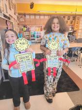 Layla Pitrelli and Aaliyah Rivera with their clock creations.