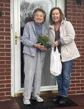 Rhea Fleckenstein, right, a volunteer with Meals on Wheels of Greater Newburgh, presents a Christmas tabletop arrangement to client Anna Alessi, along with her noontime hot meal. The arrangements, distributed to clients on Dec. 11, were prepared and donated by the Garden Club of Orange &amp; Dutchess Counties. For more information about Meals on Wheels of Greater Newburgh, call 845-562-3490 weekday mornings, or visit <a rel=nofollow href=http://www.mealsonwheelsnewburgh.org>mealsonwheelsnewburgh.org</a>.