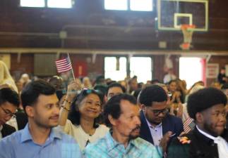 A new citizen waves the American flag before saying the oath of allegiance.