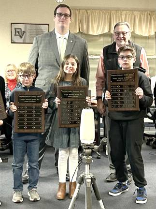 School board members Carl Will and Jack Fisher with three of the Spelling Bee winners: second grader Logan Yearwood, fifth grader Aria Gonzalez, and seventh grader Mattias Itjen grade 7.