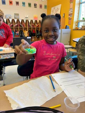 Vivian Glover shows off her rock creation.