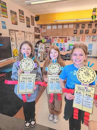 Third graders Lyla Barry, Kaylee Lefferts and Olivia Lyons with their clocks.