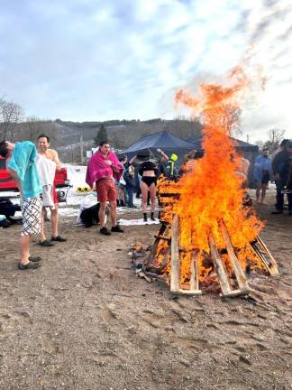 A warm fire helped the polar plungers recover from their icy dip.