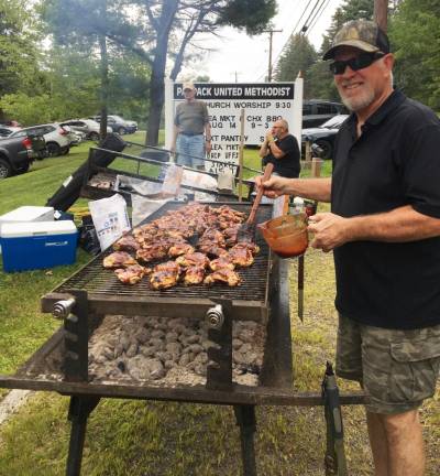 Bill Lukacinsky mans the grill at last year’s flea market/chicken barbecue at the Paupack United Methodist Church. Provided photo.