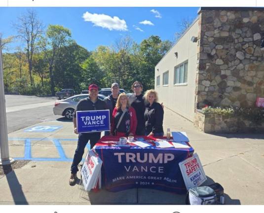 Matthew Contreras, left, and Early Vote Action’s Scott Pressler, second from right, at a Trump/Vance table set up by Contreras outside the Milford Post Office.