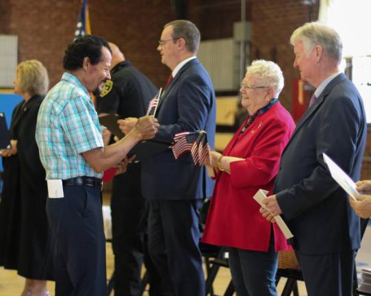 A new citizen receives an American flag at a naturalization ceremony in Newburgh. Photo: Brianna Kimmel.