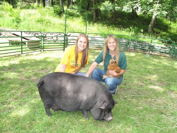 Rebecca and her mom Donna with a pot bellied pig and a chicken