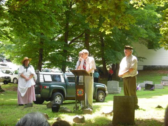 Pike County Historian George Fluhrs addresses the public. To his right is emcee Pete Bassani, and to his left Darcy Ramford of 24th CT Militia out of Wyoming Valley in 1700's costume.
