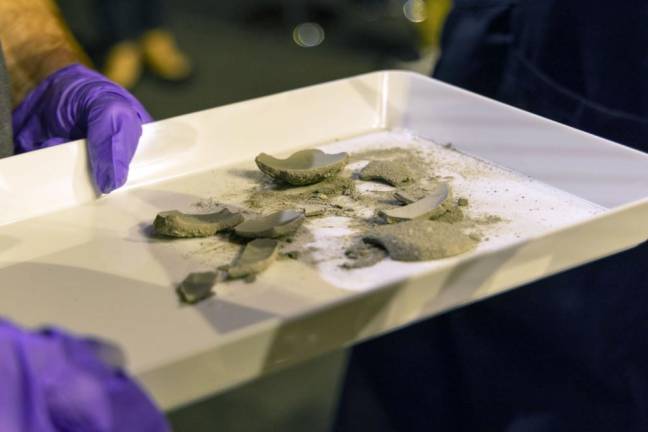 West Point archeologist Paul Hudson and West Point Museum curator Michael Diaz gingerly lifted out a few gray clumps and dusted them with a brush, only to have them crumble into powder. Photo by Christopher Hennen.