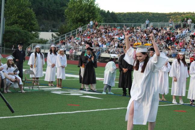 Molly Garrera celebrates as she walks to get her diploma. (Photo by Elizabeth Bobo)