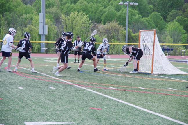 Delaware Valley goalie Keegan Heath intercepts the ball with his crosse, preventing a Vernon score.