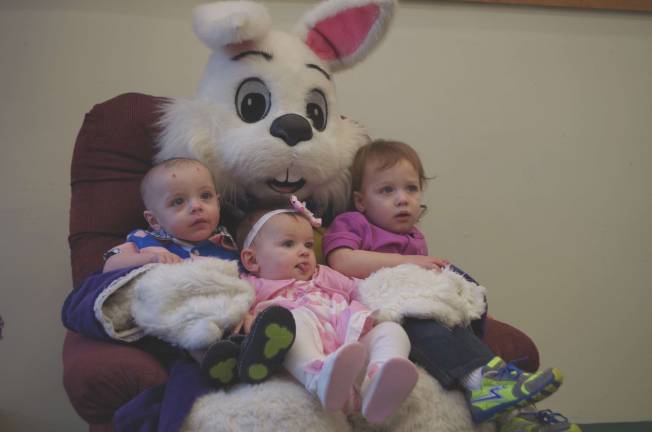 From left siblings Hunter (9 months), Baylee (9 months) and Dakotah McBride (21 months) of Milfordpose with the Easter Bunny.