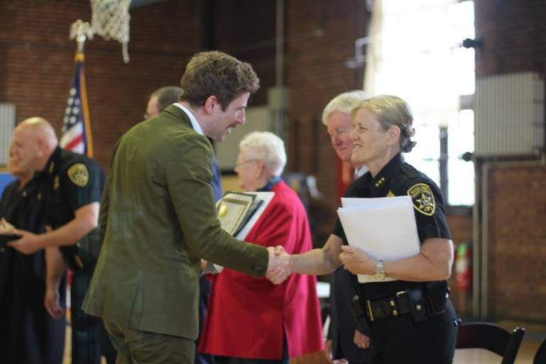 $!<b>Damien Hughes shakes hands with Undersheriff Evelyn Mallard at a naturalization ceremony in Newburgh. Photos: Brianna Kimmel</b>