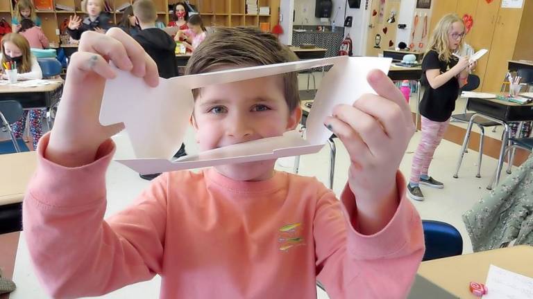 Third-grader Keston Monahan enjoys making his Valentine's box (Photo by Ped Snure)